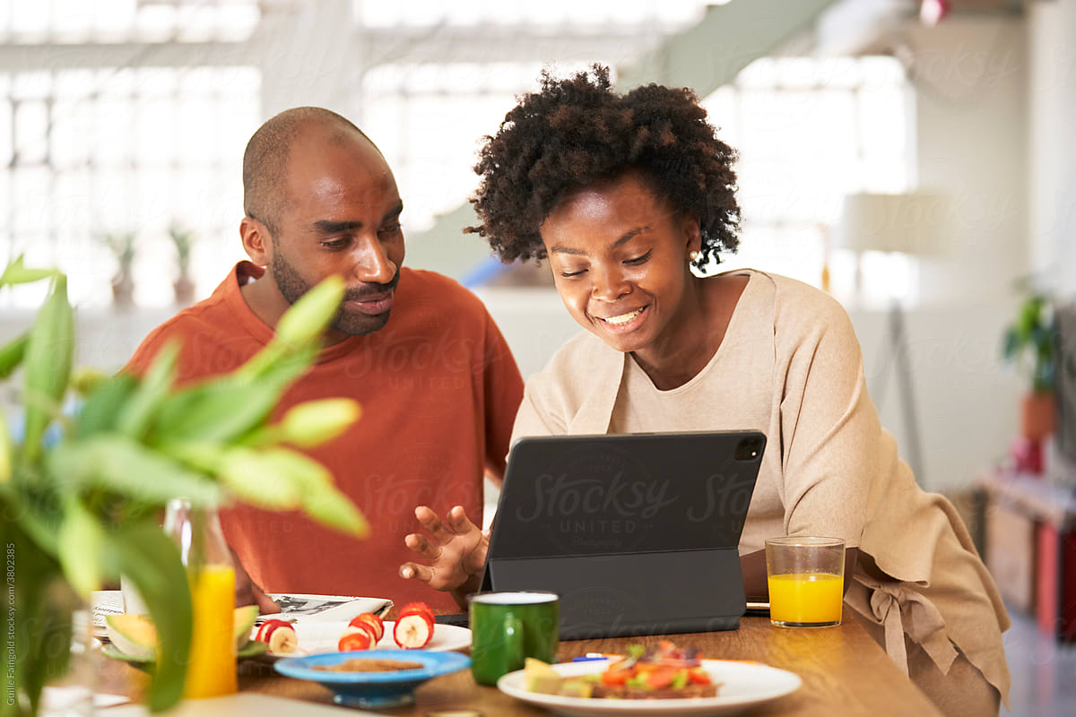 Content couple with tablet having healthy breakfast