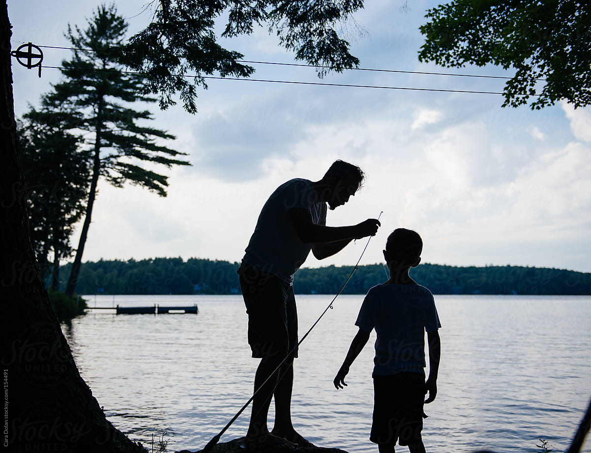 Dad Helps Son With His Fishing Pole by Stocksy Contributor Cara