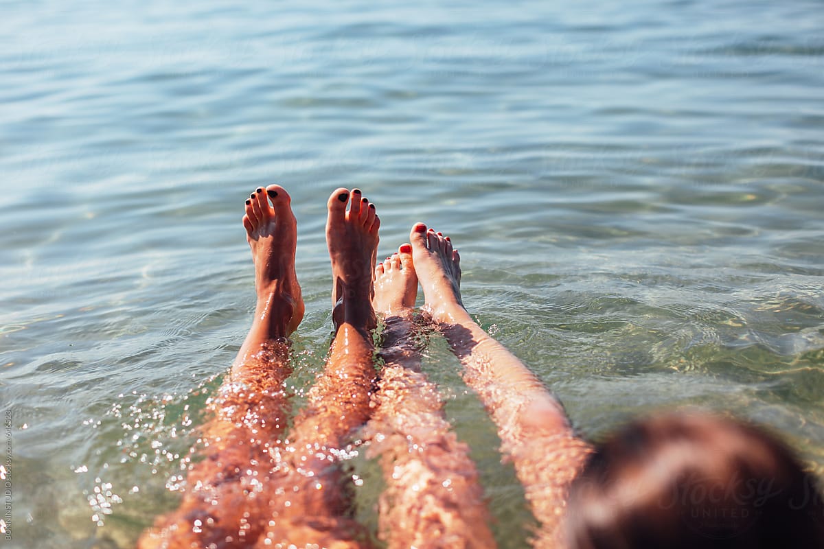 Young women legs bathing in a clear blue sea.