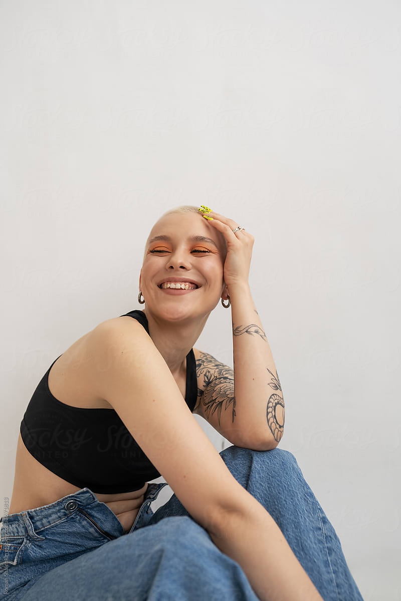 Happy informal young woman with short hair and tattoo