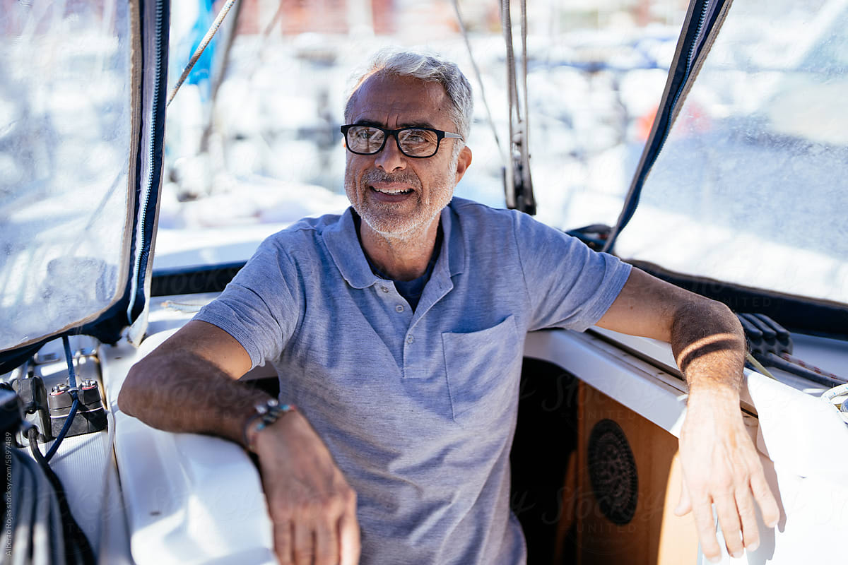 Positive sale man sitting in yacht on sunny day