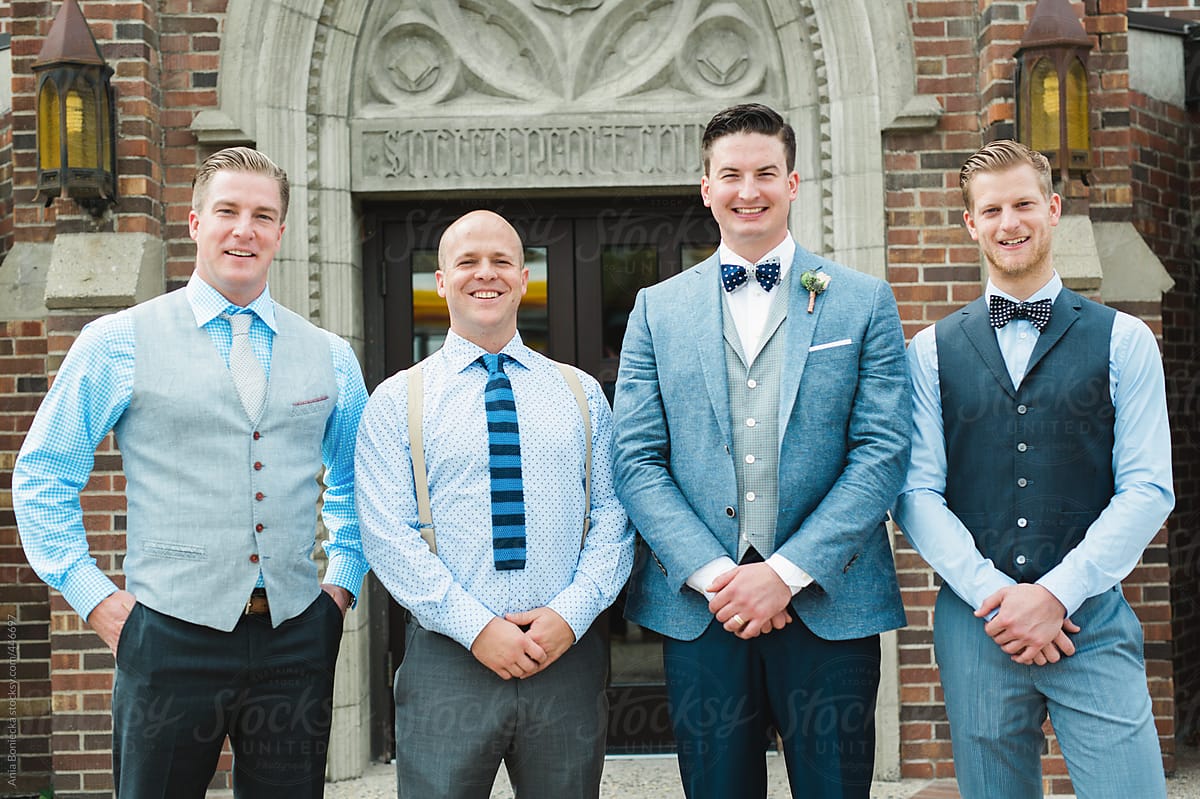 Groom and Best men smiling in front of the church