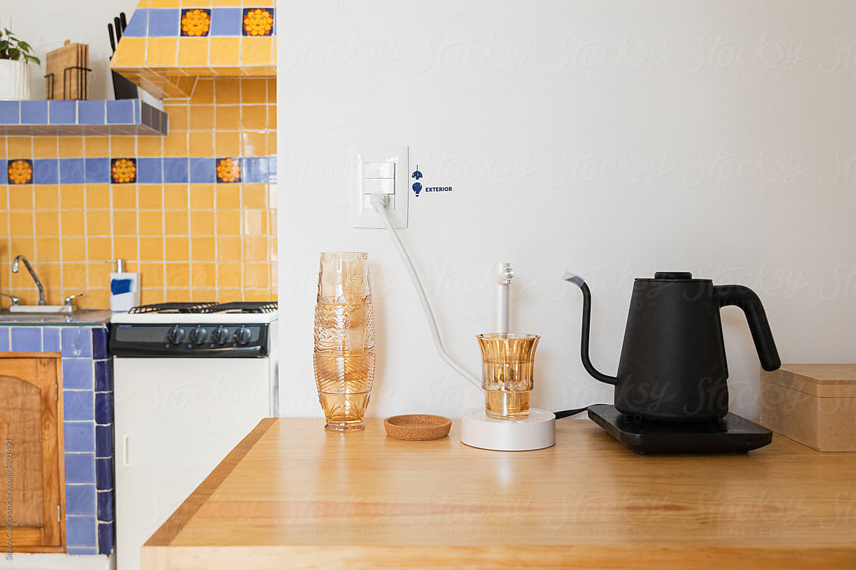 Electric kettle next to a power connection on a white wall