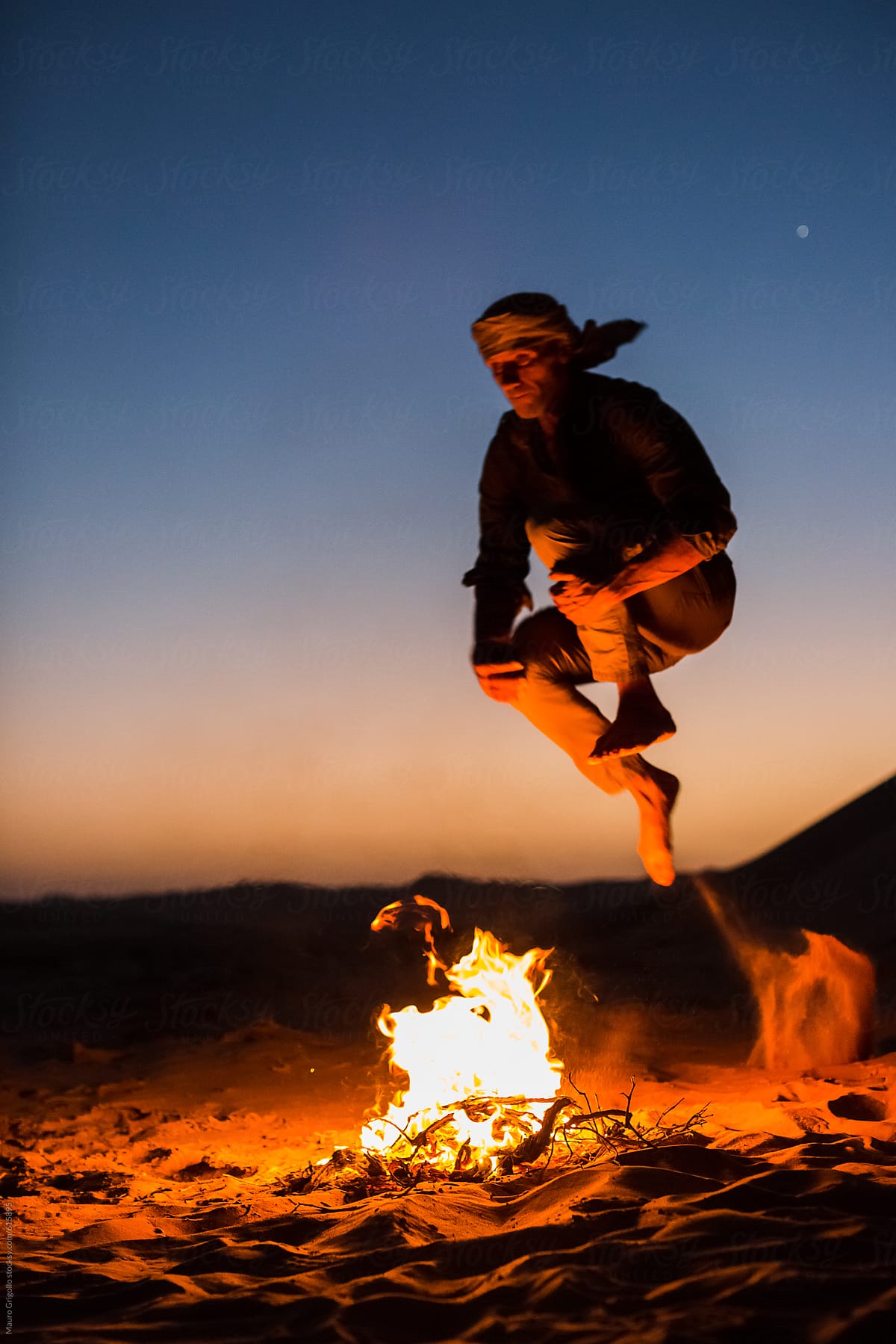 "Man Jumping Over A Fire Camp" by Stocksy Contributor "Mauro Grigollo