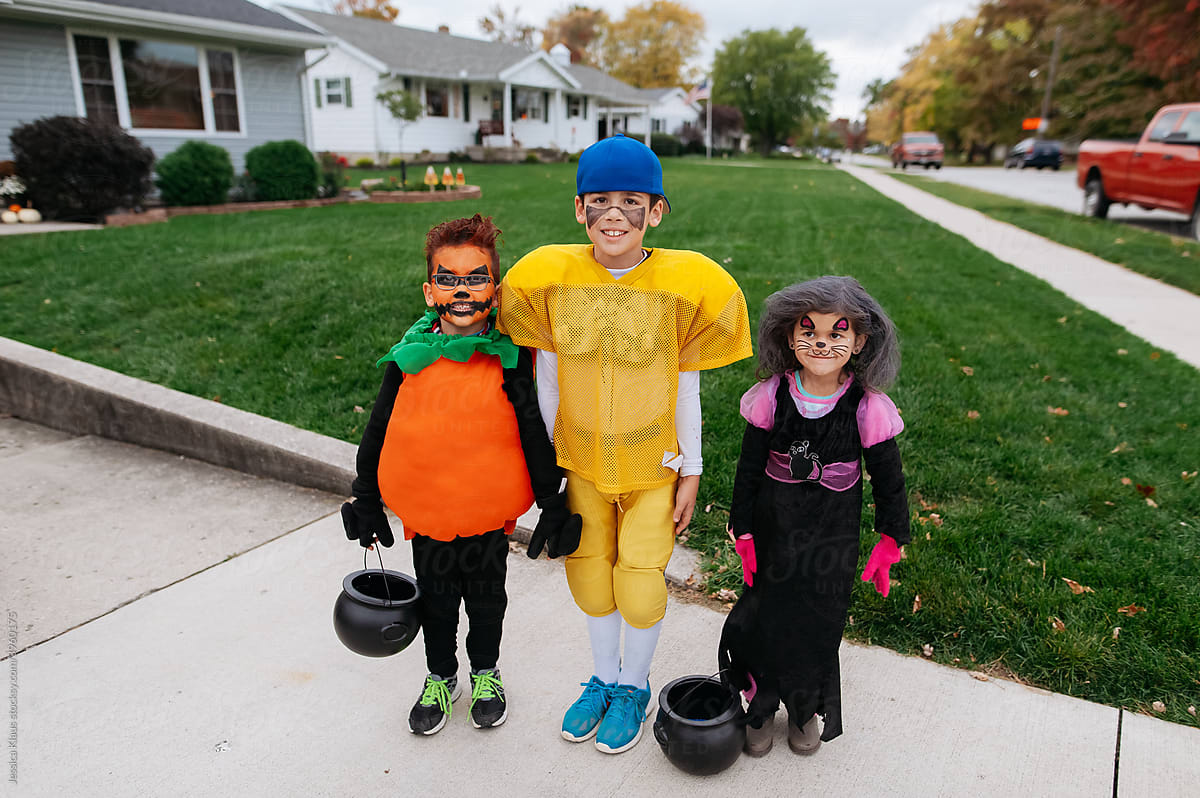 Three children getting ready for trick-or-treat.