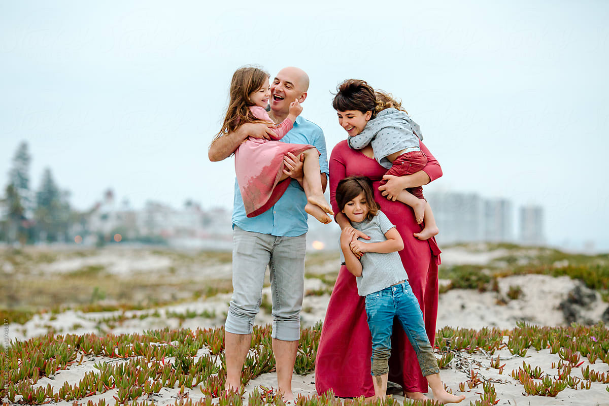 Happy family of five together on sand dune