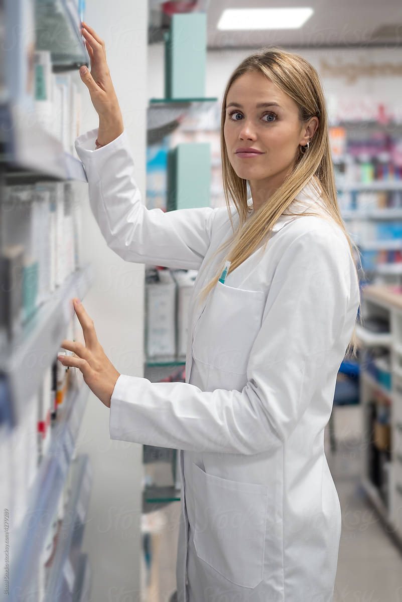 Pharmacist searching drug on shelf