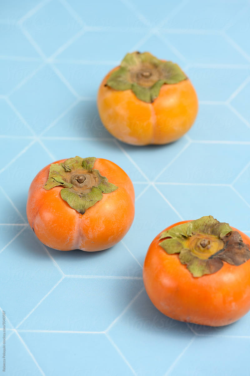 Fuyu persimmon on blue tile background