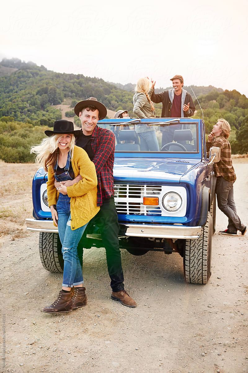Portrait of couple with group of friends in nature while on road trip