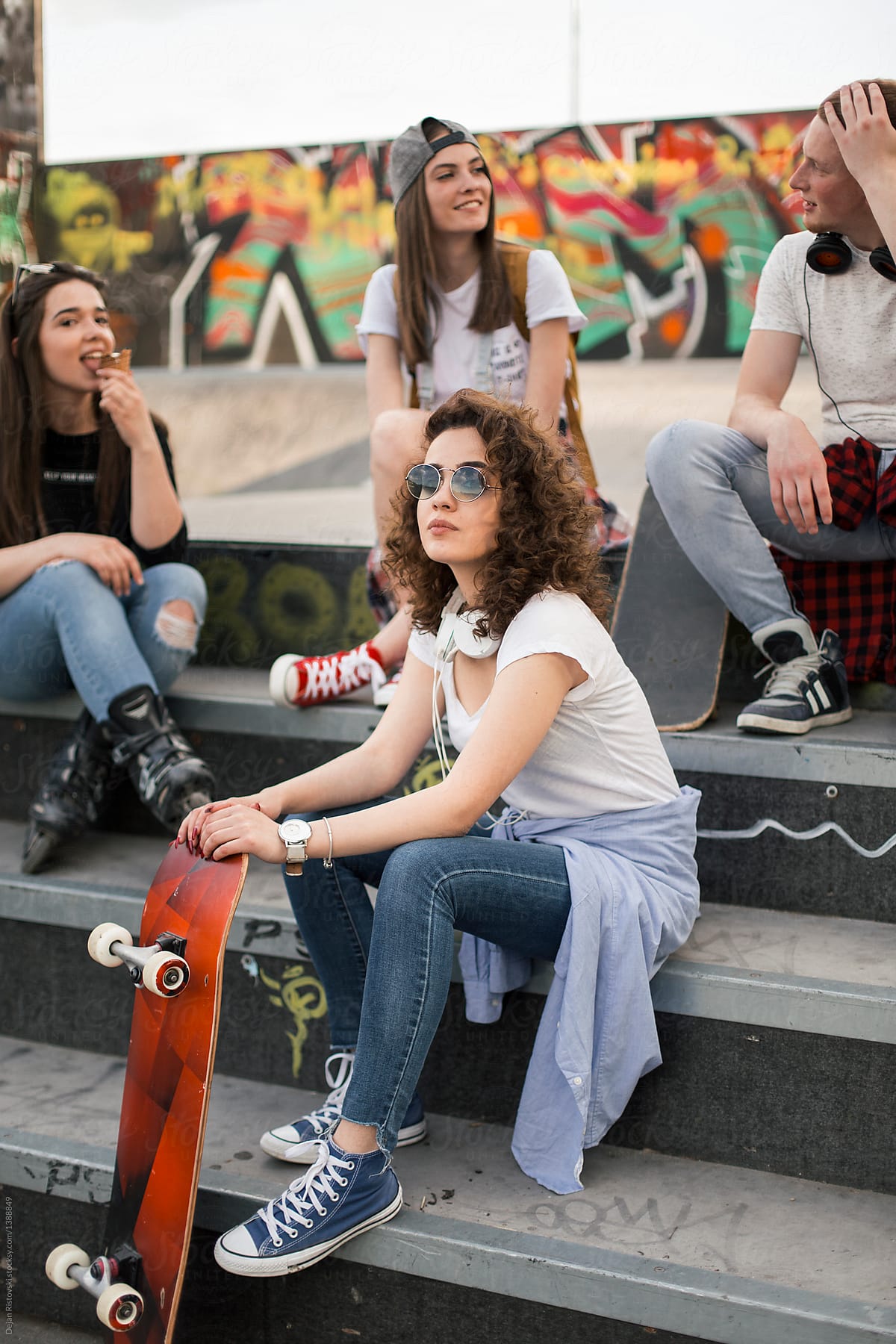 Young people sitting in skate park.