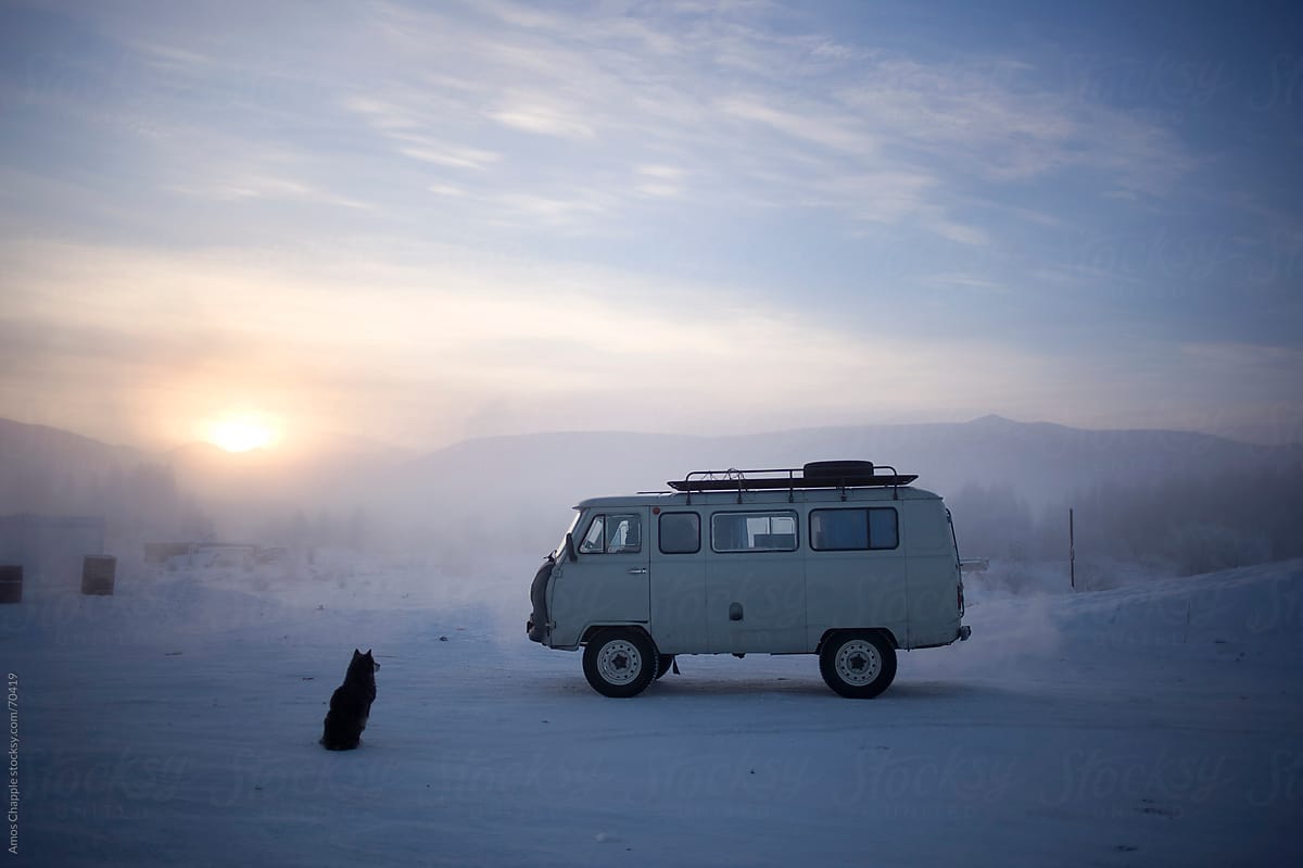 A dog waits next to a soviet-era van at a truck-stop in Siberia