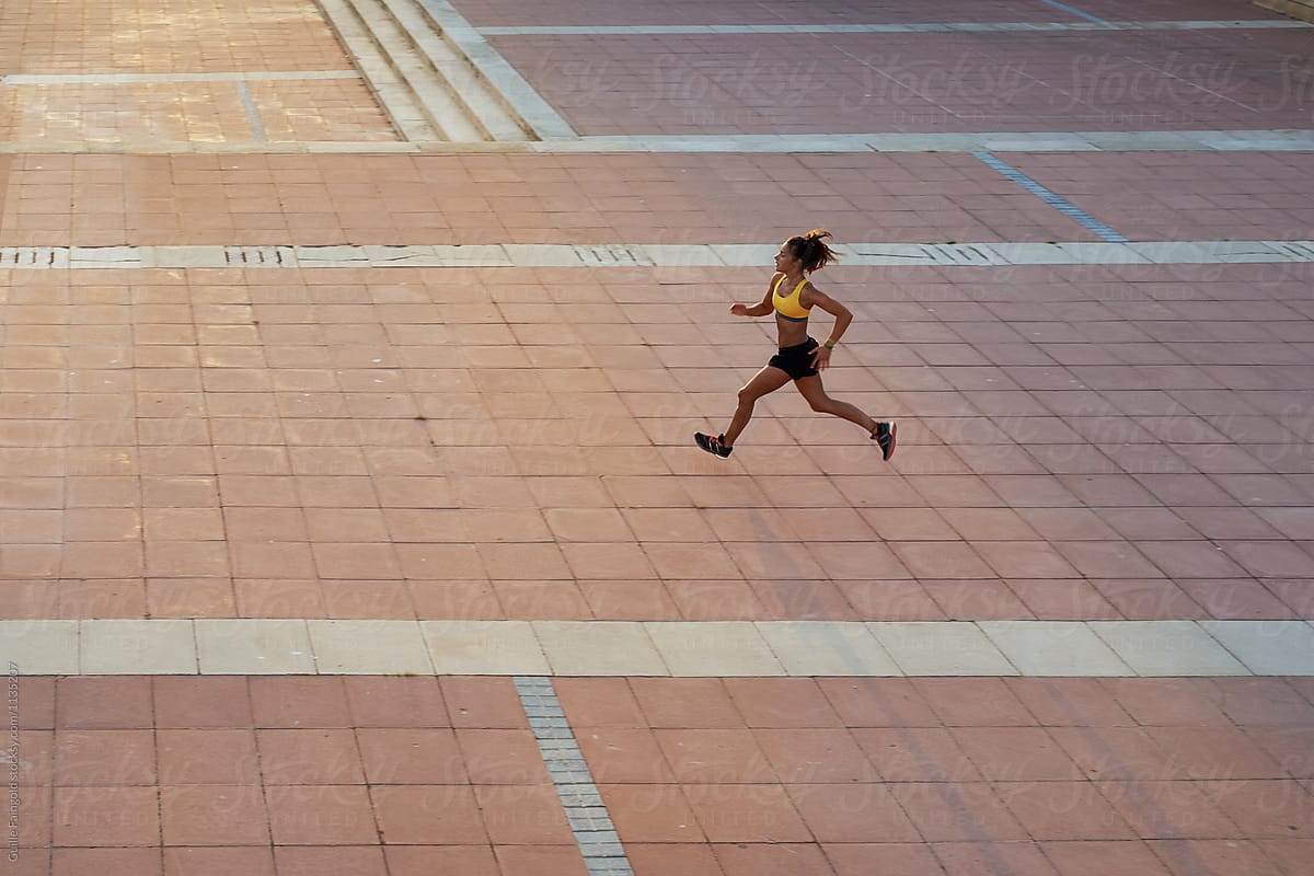 Active woman running alone on street