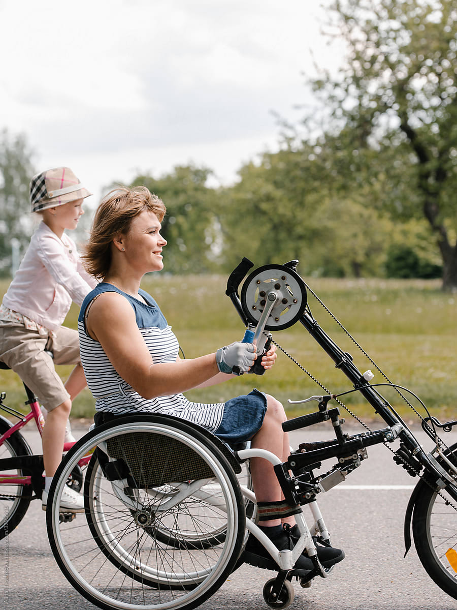 Woman with disability riding handbike near daughter