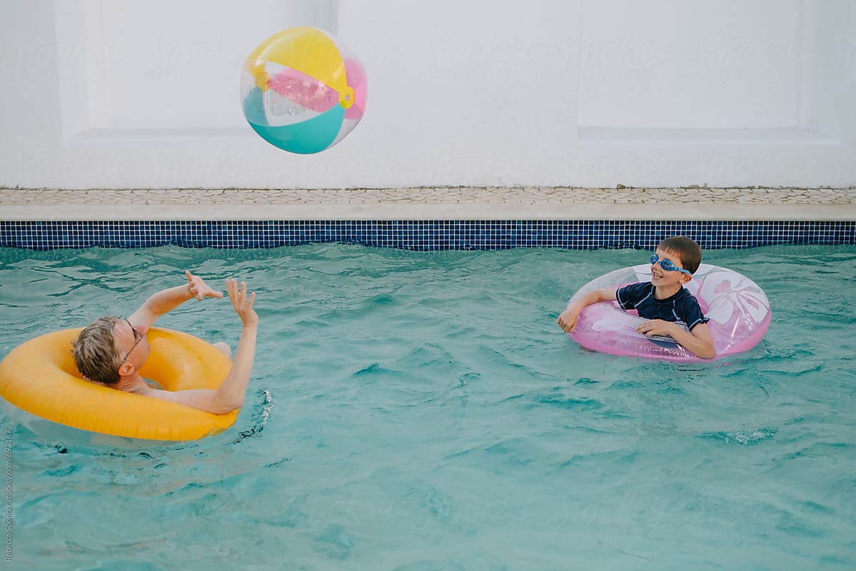 Inflatable ball flies through the air above a swimming pool