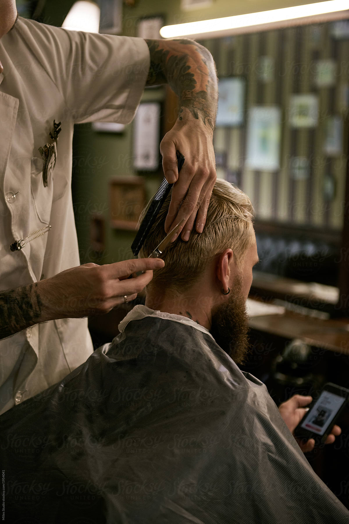 Man grooming client in barbershop