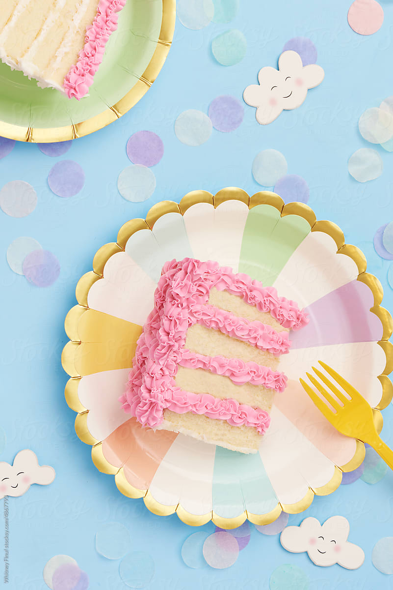 Flat lay of birthday cake with pink frosting on pastel blue background