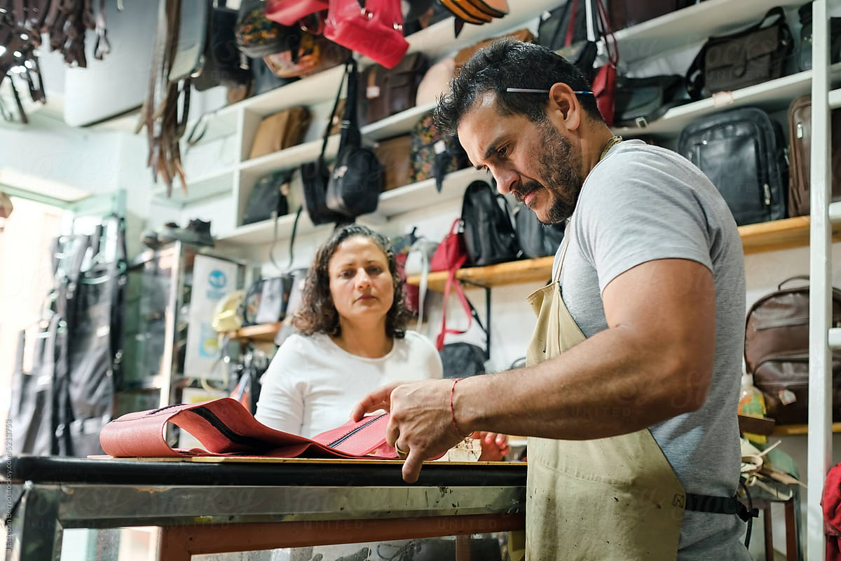 Latin couple working in a leather products workshop
