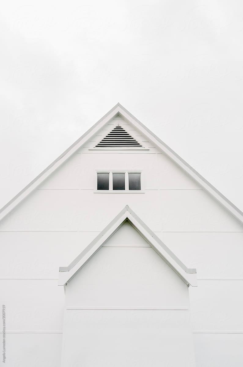 Roof of a white building against a white cloudy sky