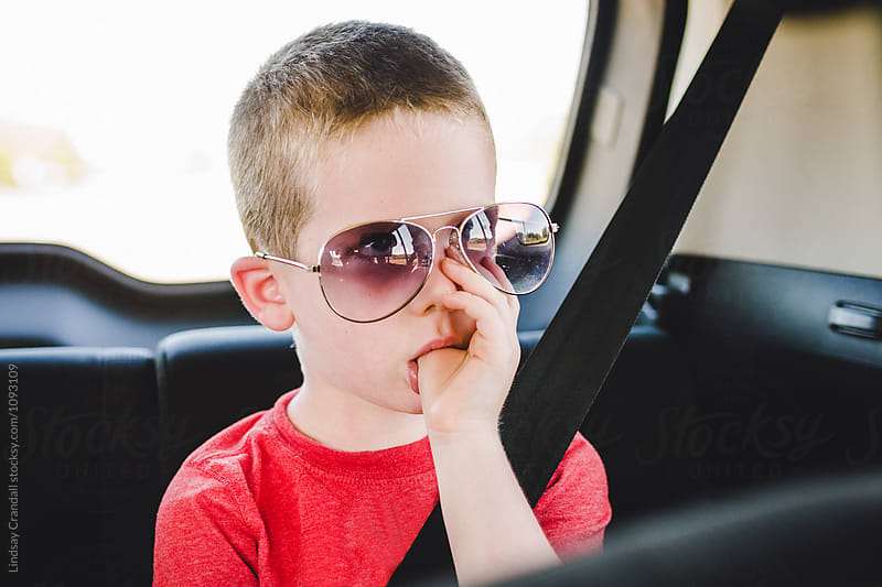 Unhappy kid in the backseat sucking his thumb