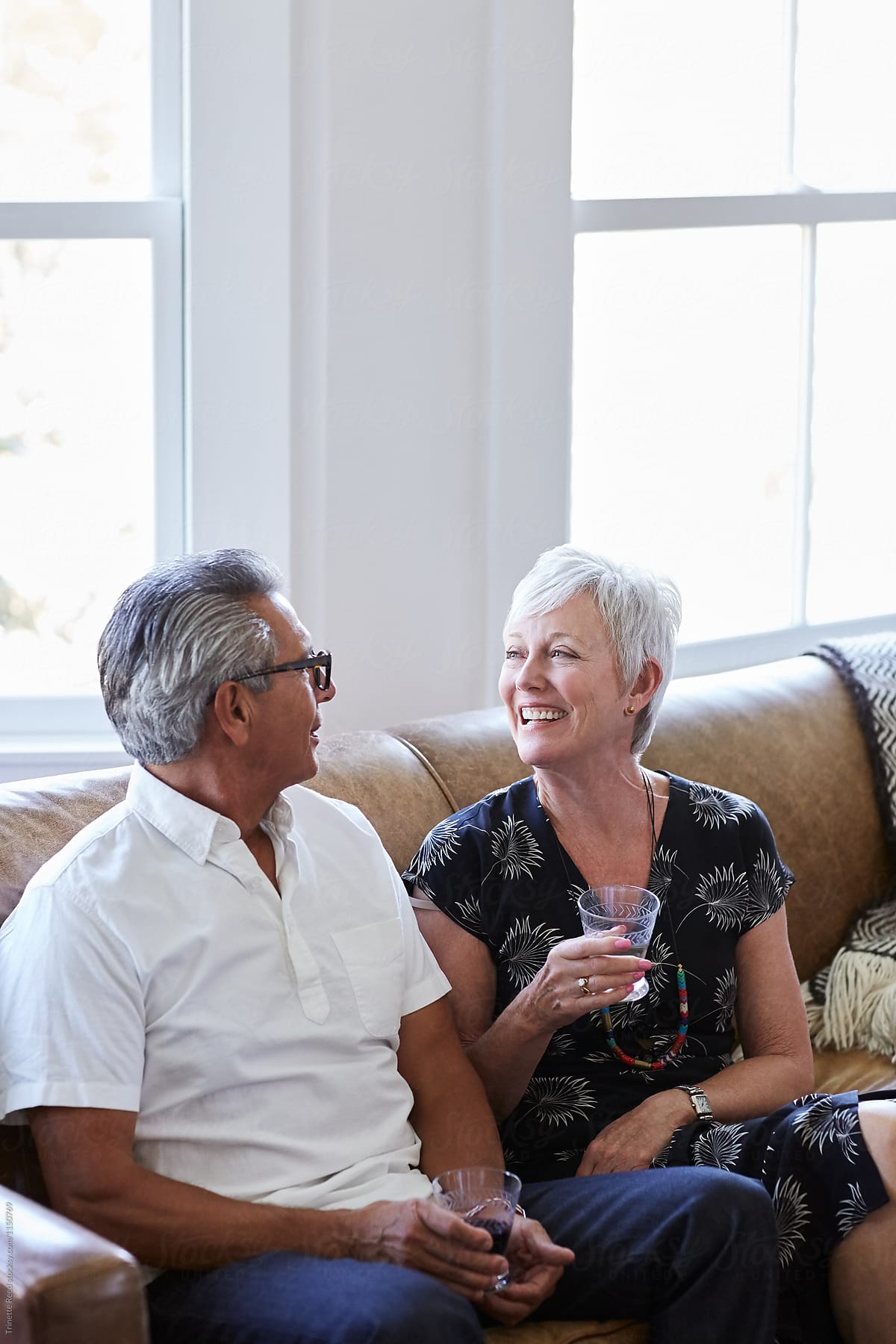 Senior couple talking at a party in living room