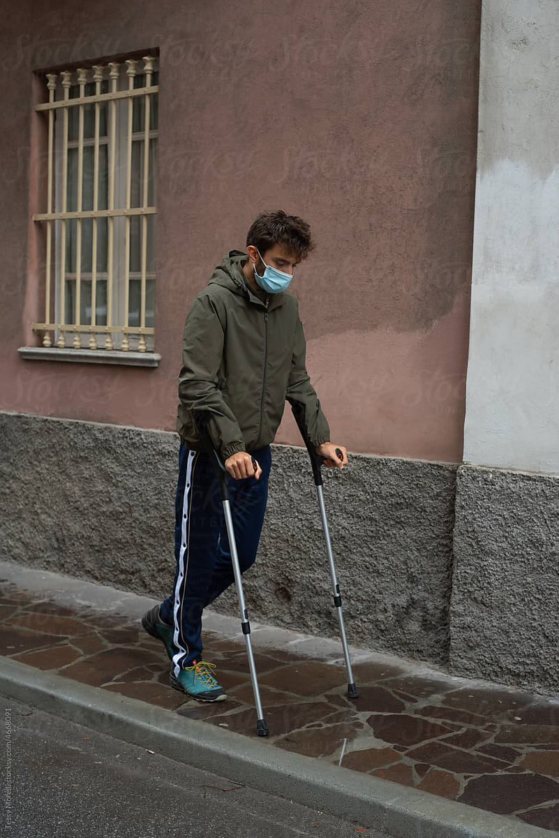 Injured patient on his first walk outside with crutches