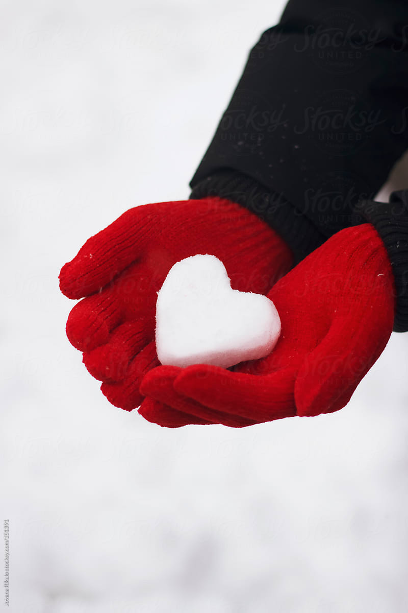 Man holding snow made heart in his hands