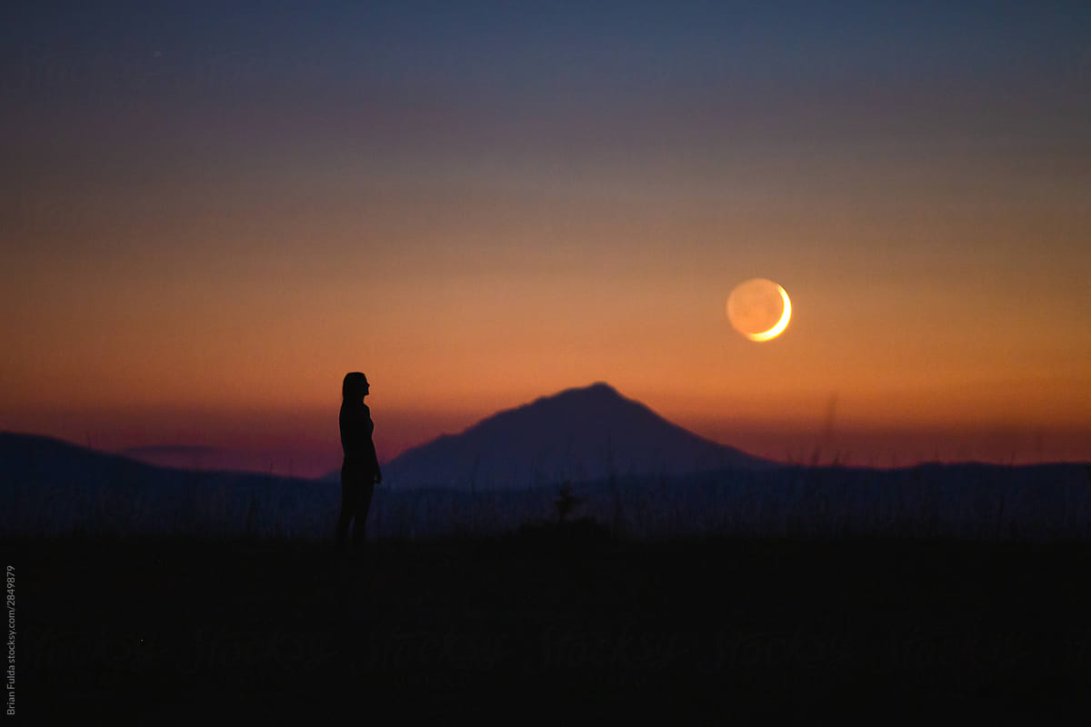 Woman Standing and Observing the Moon at Dusk