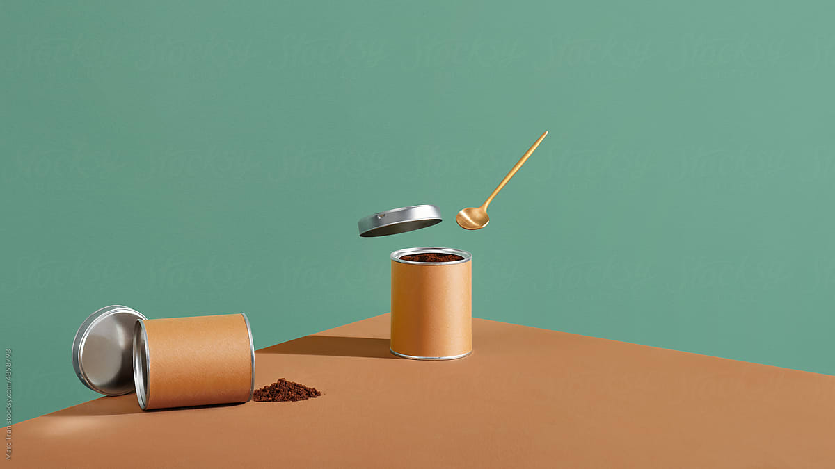 Instant coffee in a paper-tin can with spoon on a brown surface