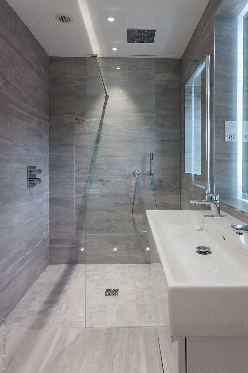 Modern shower room with grey tiling.