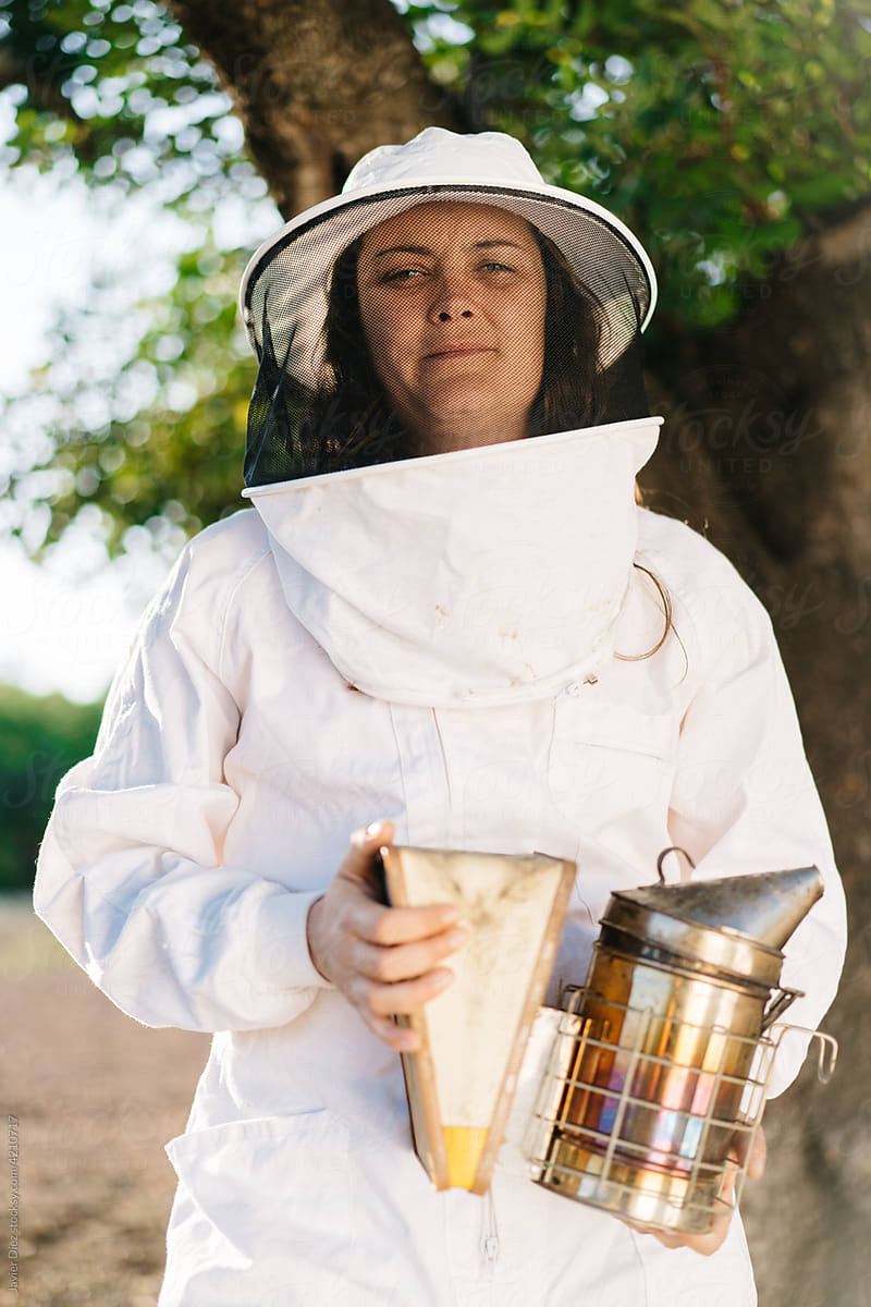 Cheerful female beekeeper on apiary