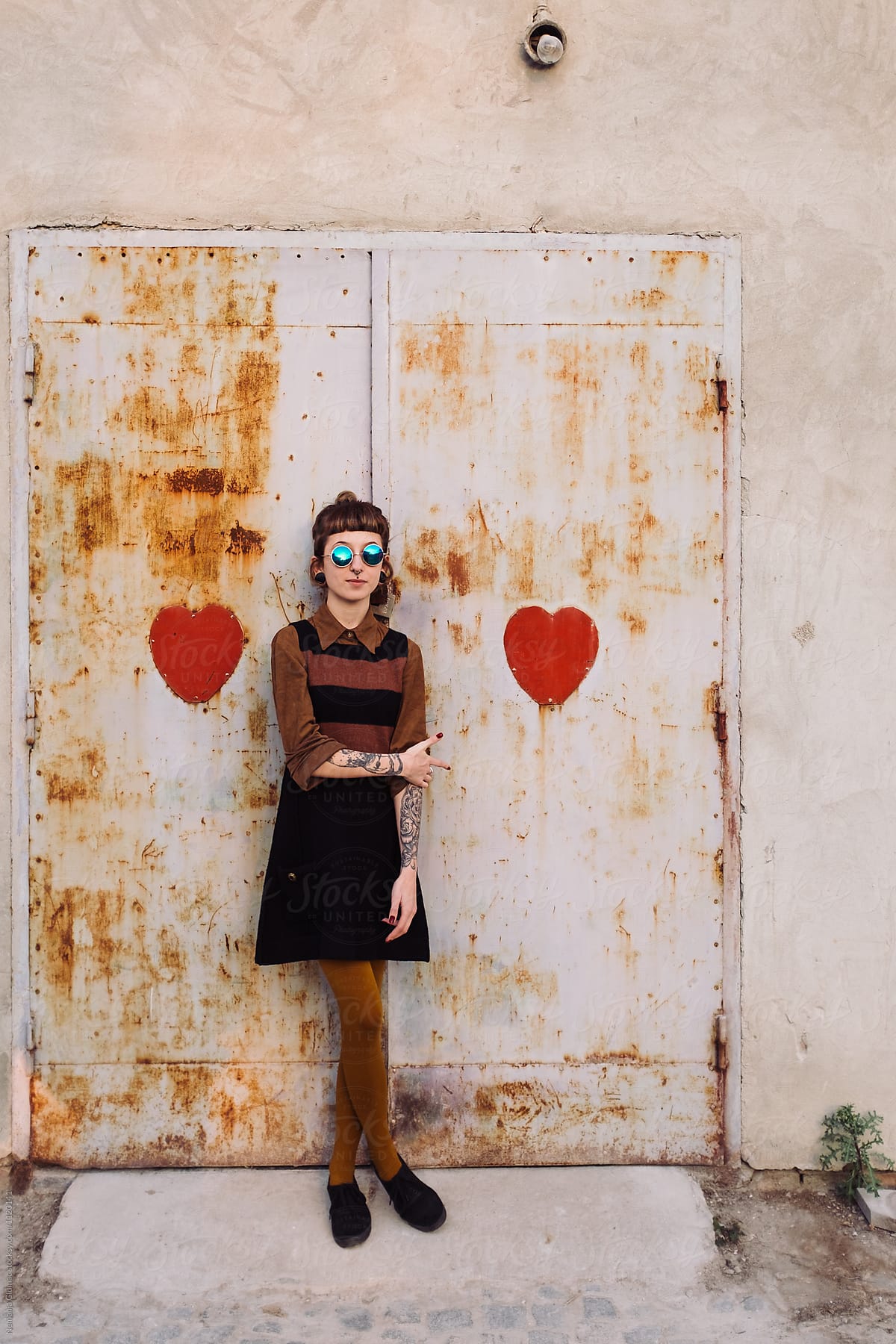 Young Woman With Tattoos Standing Between Two Hearts