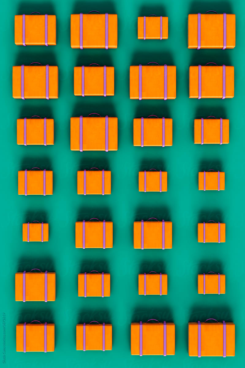 top view of orange suitcases on green background