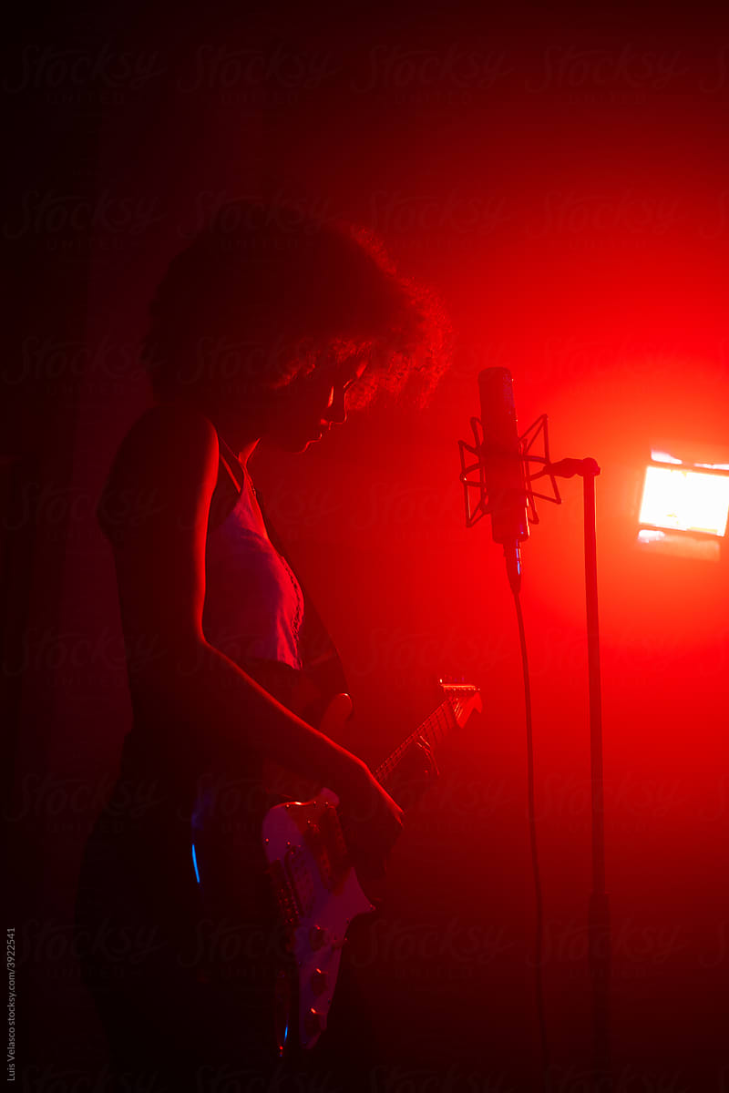 Silhouette Of Black Girl Singing And Playing The Guitar