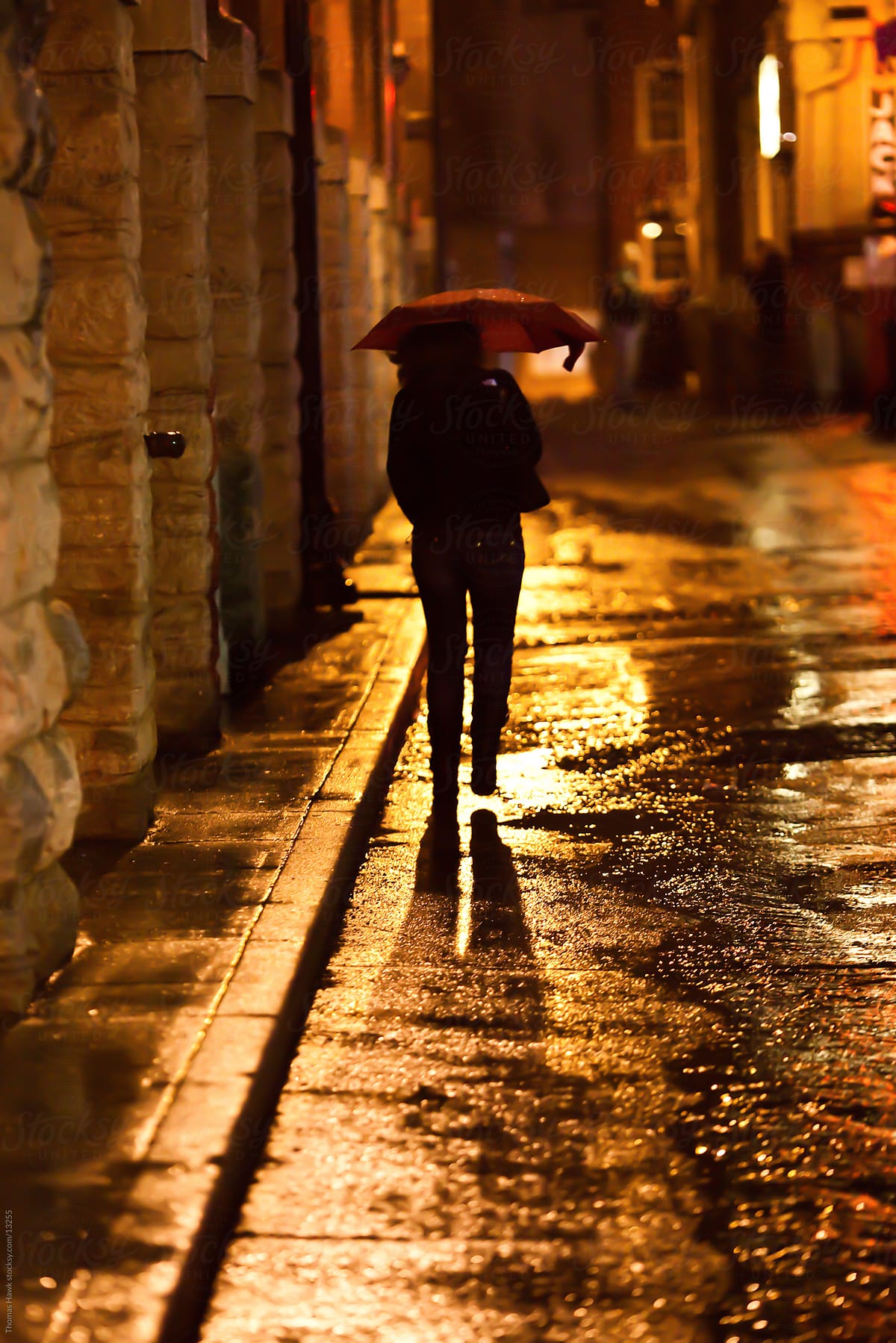 A silhouette of a woman walking in the rain at night in Nashville, TN