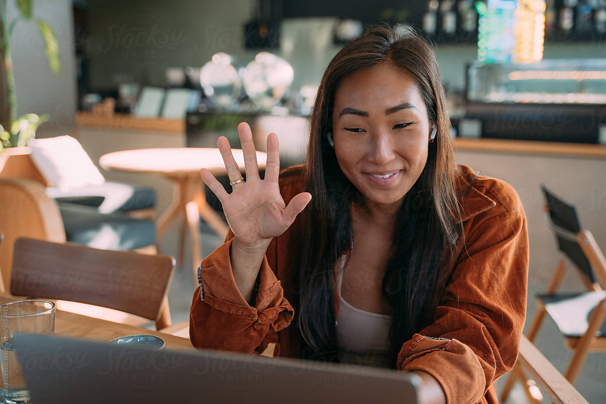 coworker waving goodbye at end of video call on laptop