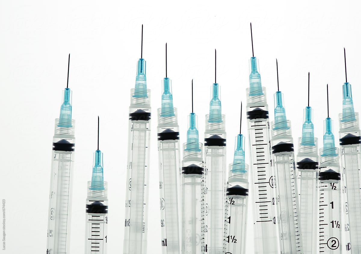 A group of hypodermic needles standing upright.