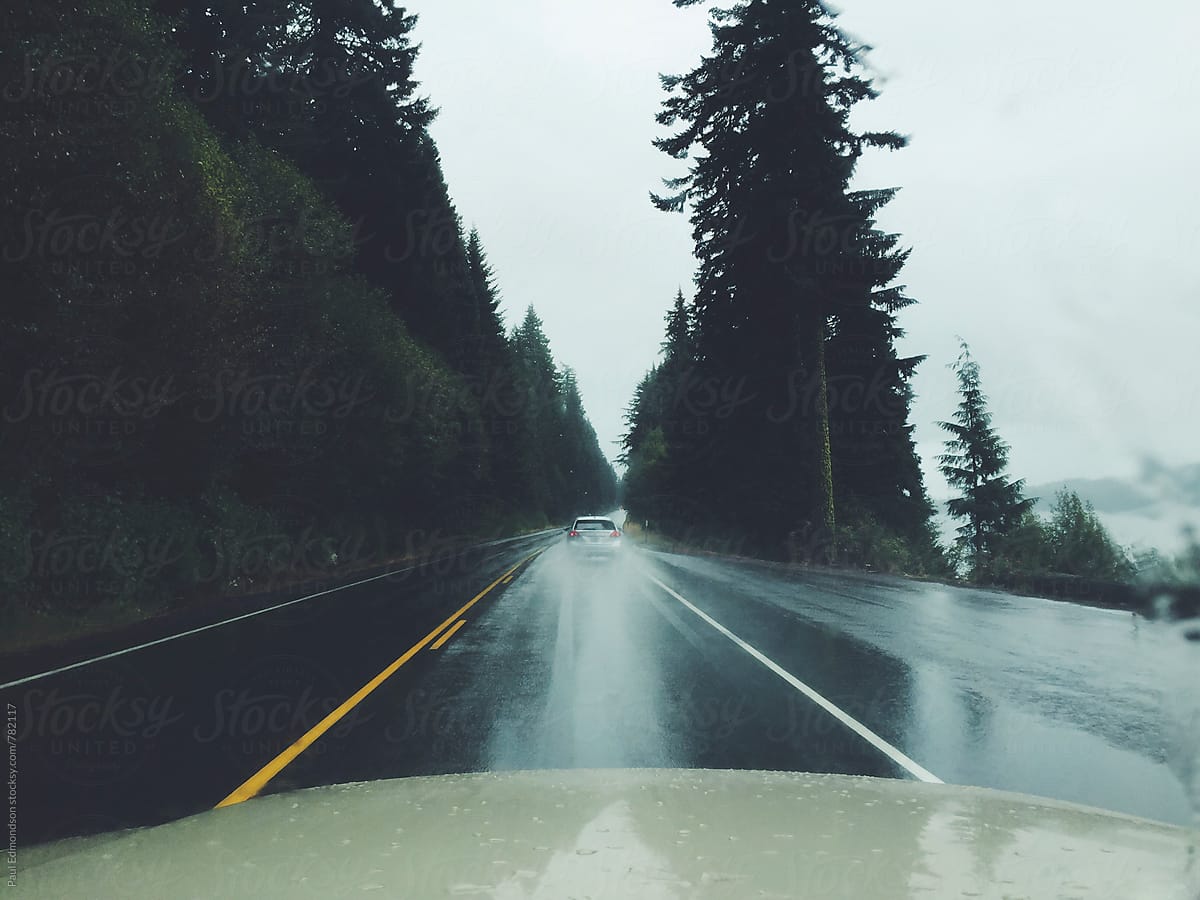 View through car windshield of road and wet weather