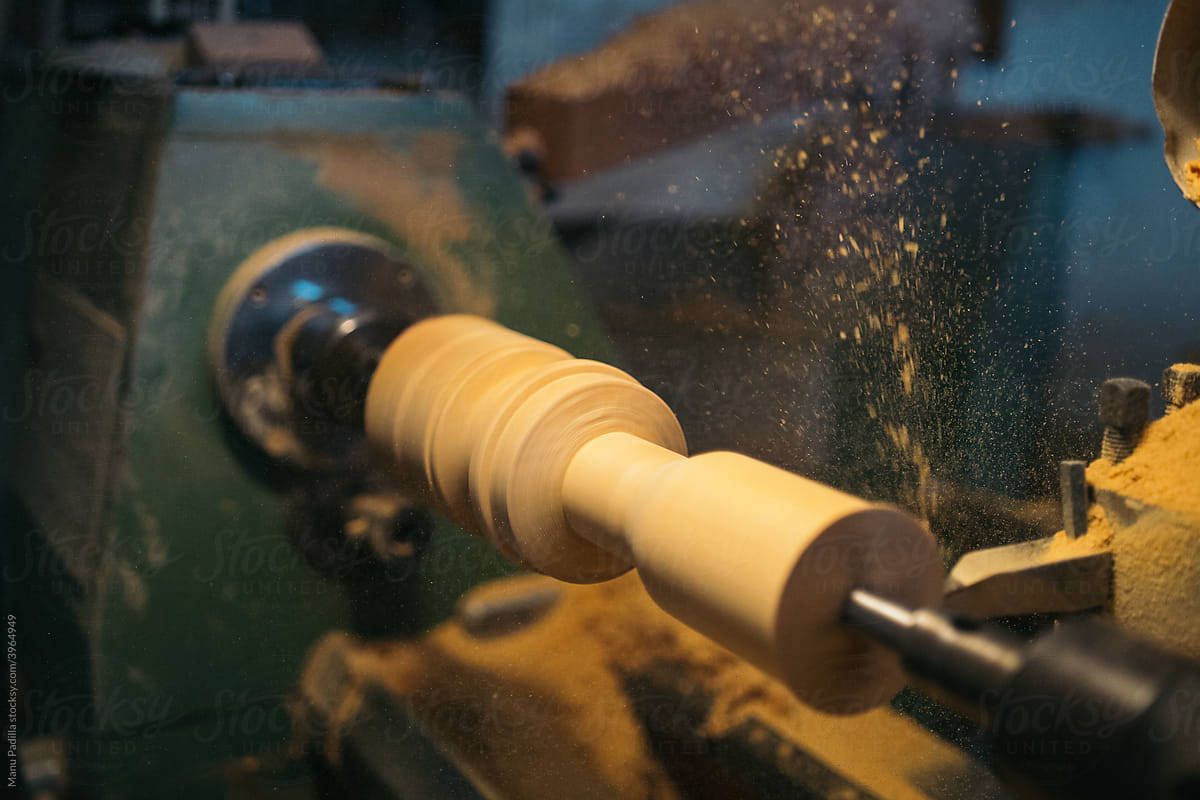Lathe carving wooden piece in workshop
