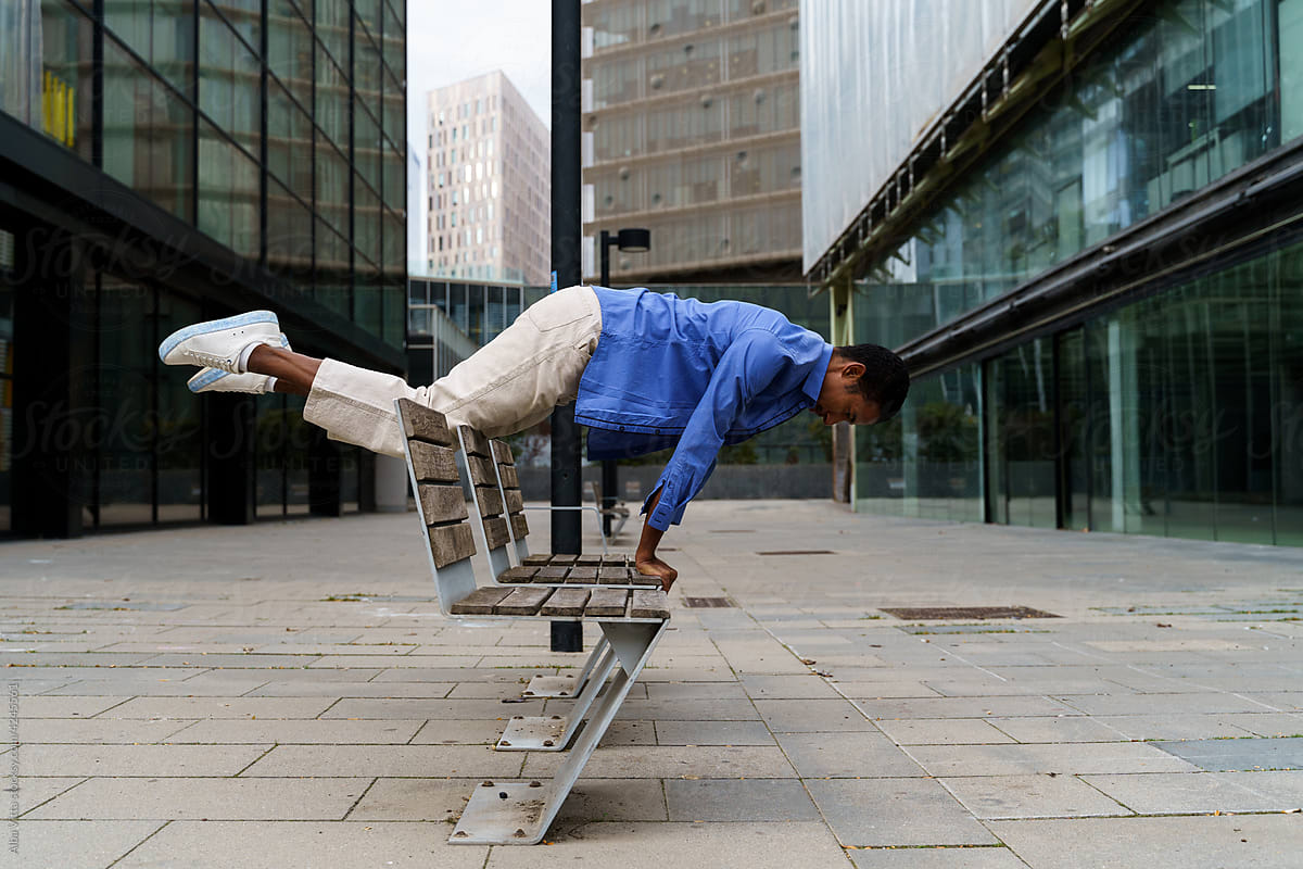 Stylish man balancing on top of  bench