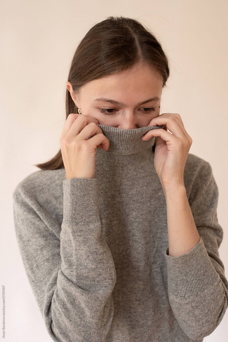 Woman hides her face with a sweater