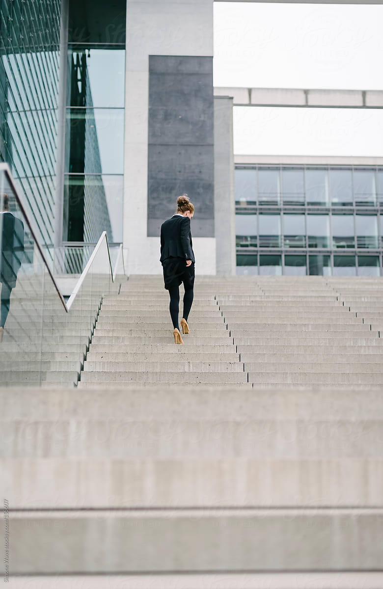Businesswoman walking on the steps of a big company