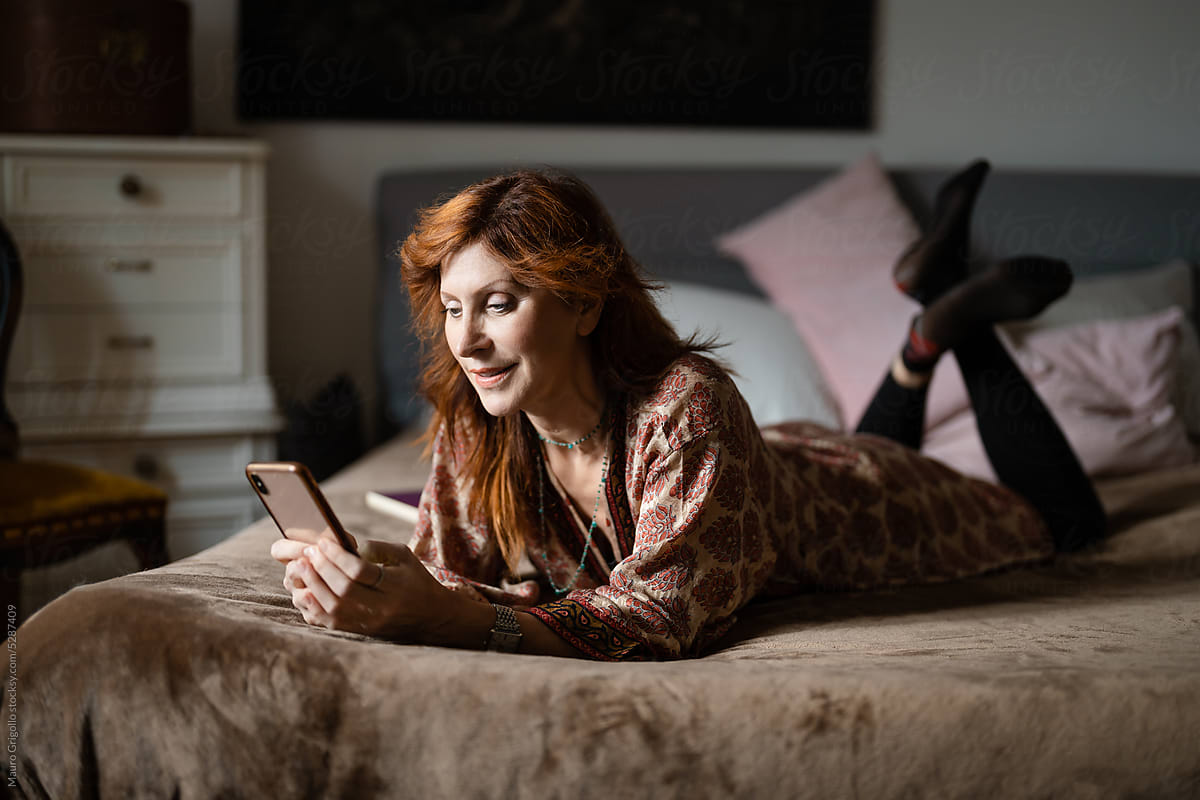 Woman use her smartphone on the bed at home