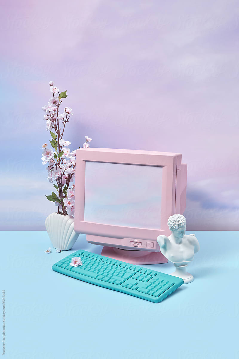 Vintage computer with statue and flowers.