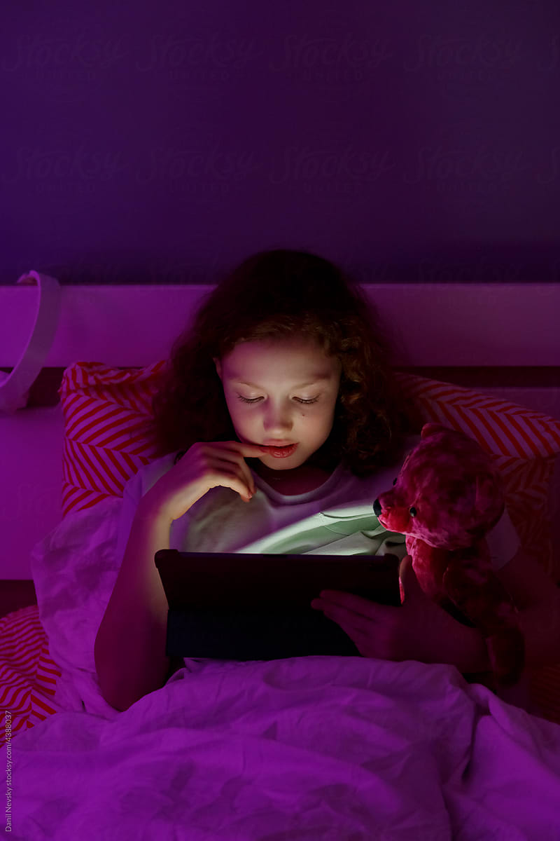 Little girl watching video at night