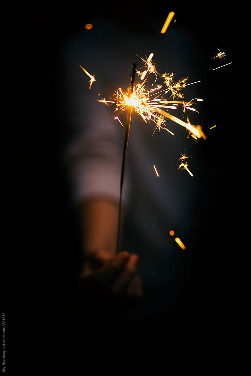 Female hand holding a sparklers at a party