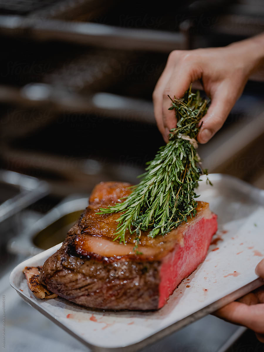 Beef being rubbed with Rosemary