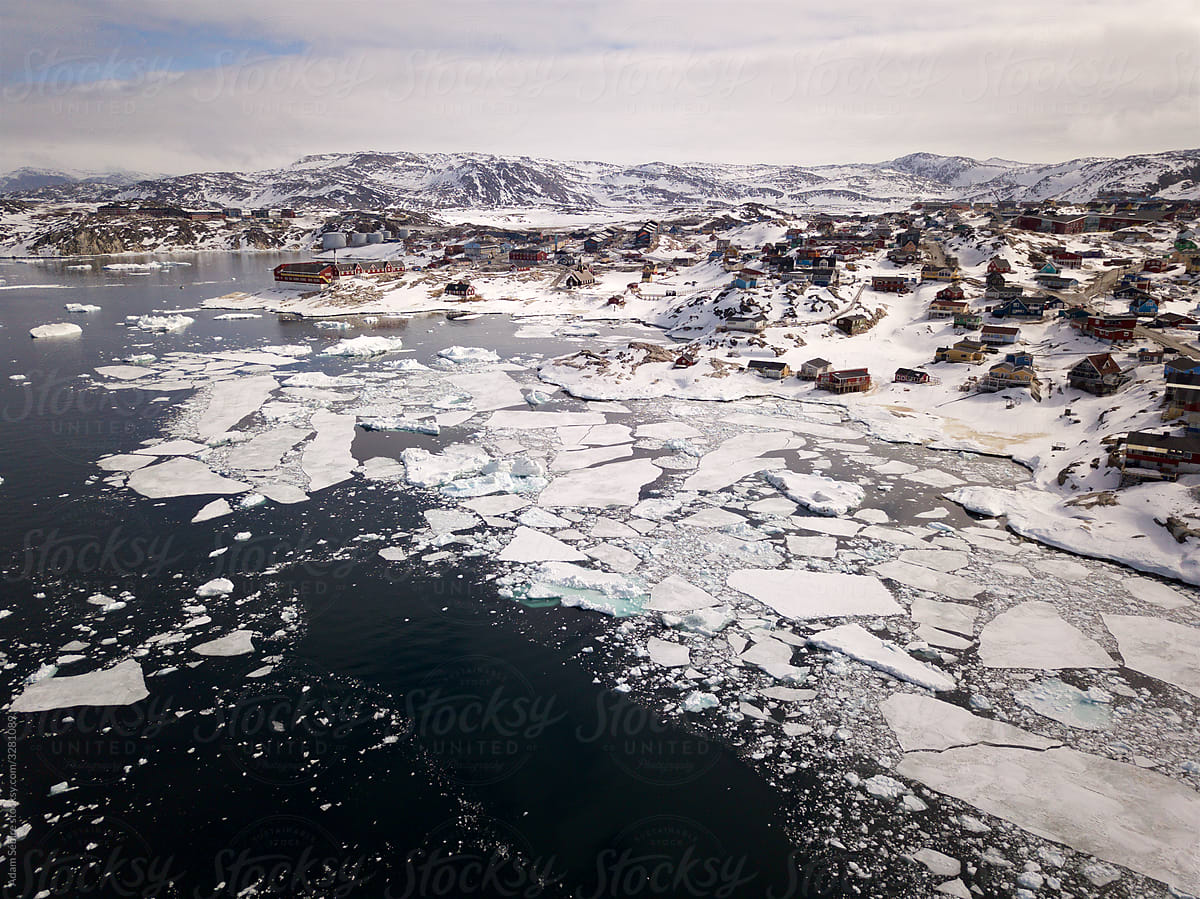 Greenland melting, Ilulissat harbor, aerial drone of town as sea-ice breaks up