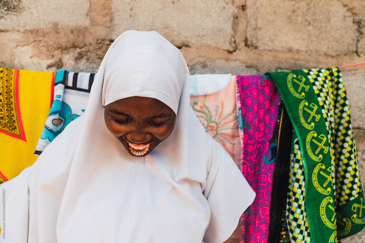 Close up of a girl laughing wearing a muslim school uniform.