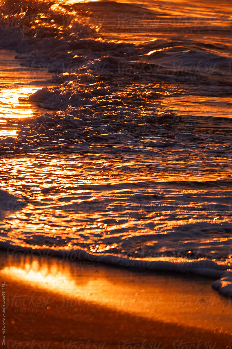 Dramatic orange sunrise on beach.