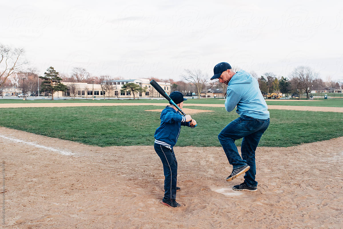 Dad showing baseball bat swinging tricks to his son